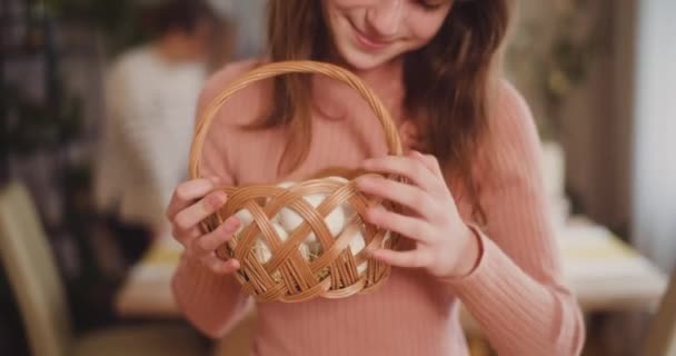 小女孩在节日桌上把复活节彩蛋放在篮子里的肖像 — 图库视频影像