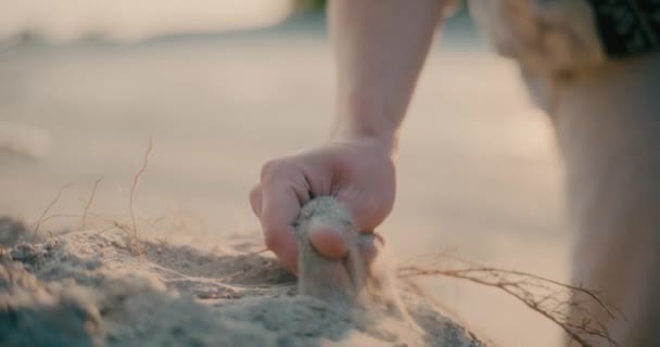 インスピレーションハードタイムの概念を探しているビーチで砂に触れる人間の手の閉鎖 — ストック動画