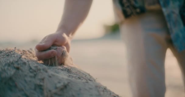 インスピレーションハードタイムの概念を探しているビーチで砂に触れる人間の手の閉鎖 — ストック動画