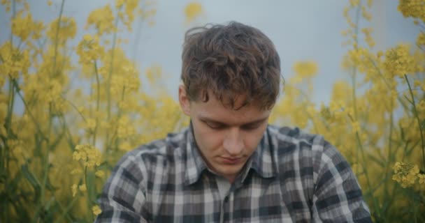 Zpomalený Pohyb Mladého Farmáře Uprostřed Žlutých Květin Kvetoucích Farmě — Stock video
