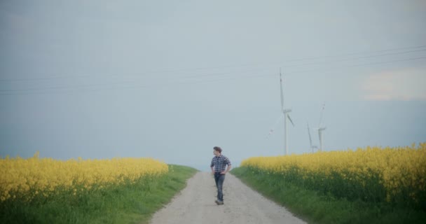 Αργή Κίνηση Του Νεαρού Αρσενικού Αγρότη Περπατώντας Στο Χωματόδρομο Ανάμεσα — Αρχείο Βίντεο