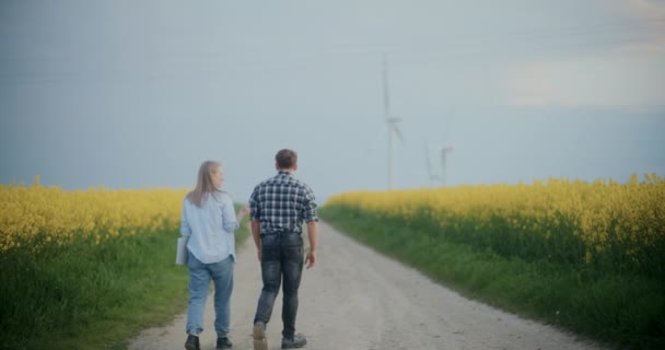 Bakifrån Kvinnliga Agronomen Diskuterar Med Bonden När Går Grusväg Mitt — Stockvideo