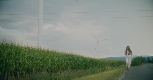 Yavaş Çekim Elleri Ceplerinde Genç Bir Kadın Rüzgar Çiftliği Yakınlarında — Stok video