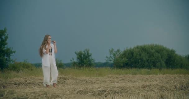 年轻女子站在草地上背对天空时戴太阳镜的慢镜头 — 图库视频影像