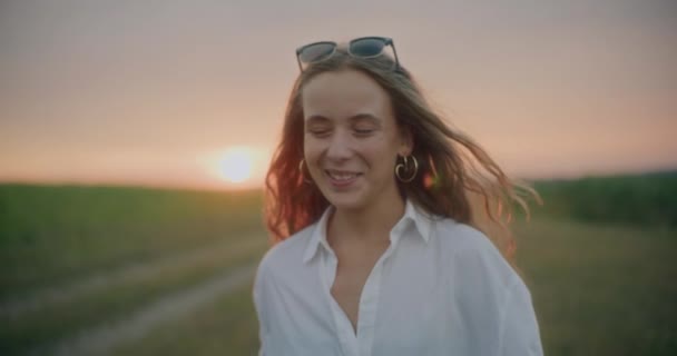 Strzał Zwolnionym Tempie Szczęśliwej Kobiety Okularach Przeciwsłonecznych Spacerującej Łące Przeciwko — Wideo stockowe