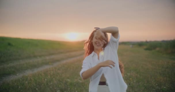 夕暮れ時に空に向かってレジャー時間を過ごしながら踊る幸せな若い女性のスローモーションショット — ストック動画