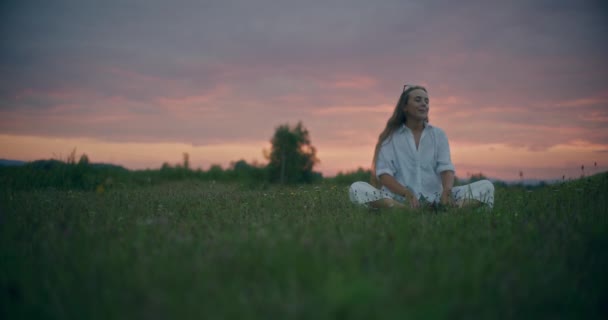 Lento Tiro Movimento Mulher Meditando Enquanto Sentado Grama Prado Contra — Vídeo de Stock