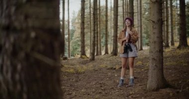 Tatil sırasında ormanda keşfe çıkan genç bir kadın şişe kapağını açıyor.