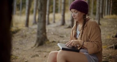 Tatil sırasında ormanda boş zaman geçirirken kadın turist günlük okuyor
