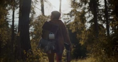 Yaz tatilinde ormanda gezen sırt çantalı genç bir kadın.
