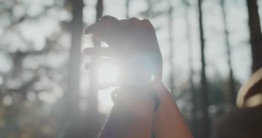 Güneşli bir günde yaz tatili sırasında ormanda el kol hareketi yapan kadınların elleri