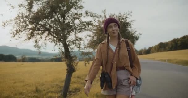 Turista Femenina Con Sombrero Punto Mientras Camina Por Carretera Contra — Vídeos de Stock
