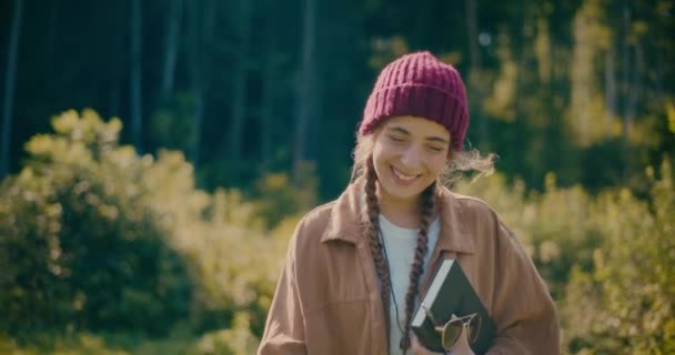 快乐的年轻女子头戴针织帽子 在森林里度假 — 图库视频影像