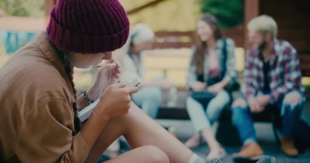Mujer Joven Con Sombrero Punto Escrito Diario Con Amigos Sentados — Vídeo de stock