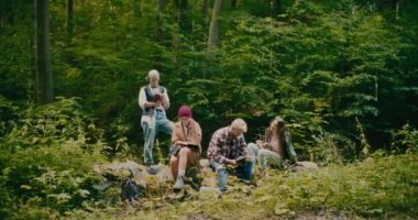 Genç erkek ve dişi yürüyüşçüler boş zamanlarını ormanda ağaçların arasında geçiriyorlar.