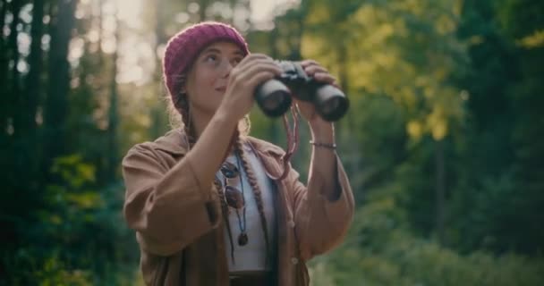 Sorrindo Jovem Mulher Usando Chapéu Malha Olhando Através Binocular Floresta — Vídeo de Stock