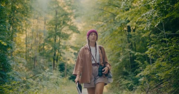 Kitapla Dürbünle Yorgun Genç Bir Kadın Ormanda Ağaçların Arasında Yürüyor — Stok video