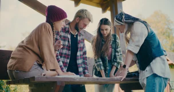 Manliga Och Kvinnliga Vänner Planerar Tillsammans När Står Runt Bordet — Stockvideo