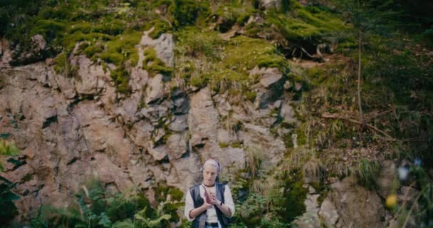 Young Thoughtful Woman Book Standing Amidst Rocks Plants Forest — Stock Video