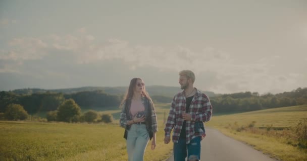 Erkek Dişi Arkadaşlar Gökyüzüne Karşı Çayırda Yürürken Konuşuyorlar — Stok video