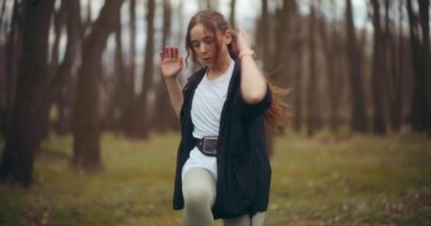 アクティブな美しい若い女性アスリートは 庭で運動しながら膝からベルボーを伸ばします — ストック動画