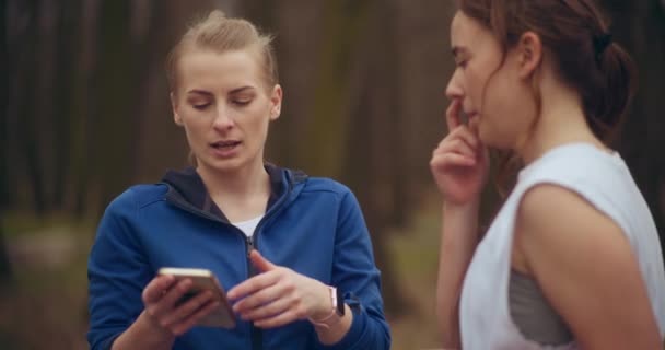 Mujer Joven Usando Teléfono Inteligente Pie Por Una Amiga Jardín — Vídeo de stock