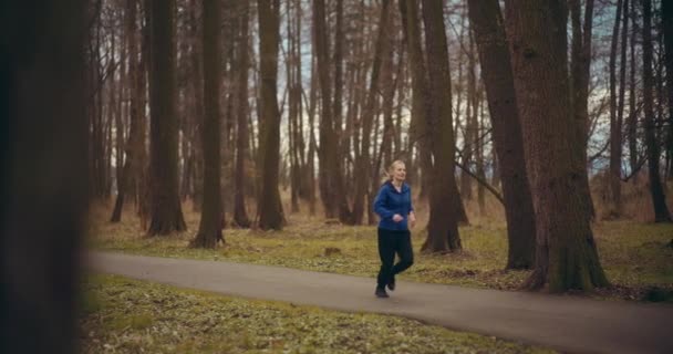 フィット若い女性は 庭でストリートで暖かい運動をしている間 女性の友人によってジョギング — ストック動画