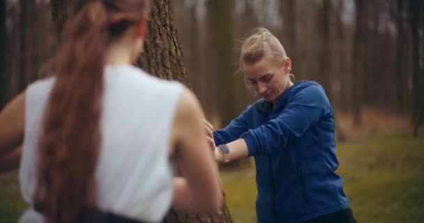 Wanita Muda Dengan Dedikasi Berlatih Peregangan Latihan Sambil Bersandar Pohon — Stok Video