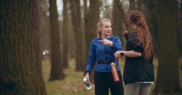 Młoda Kobieta Rozmawia Przyjaciółką Biegnie Wśród Drzew Ogrodzie — Wideo stockowe