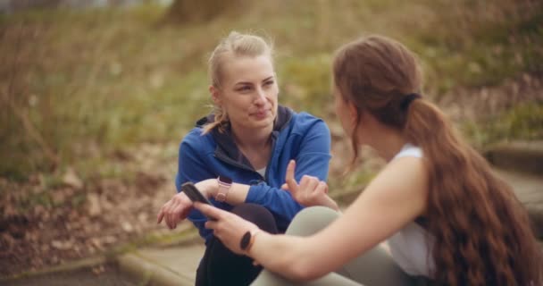 Femeie Tânără Care Vorbește Prietenă Sex Feminin Care Împărtășește Telefonul — Videoclip de stoc