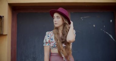 Çekici sarışın kadın. Şapka takıyor ve tatilde şehre bakıyor.