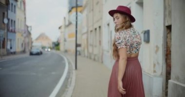 Tatilde yaya geçidinde yürürken şapka takan bir kadın.