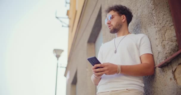 Молодой Человек Отправляет Смс Мобильный Телефон Стоя Напротив Здания Выходные — стоковое видео