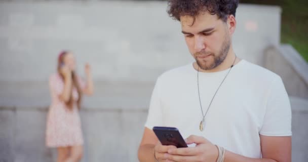 Молодой Человек Смс Мобильном Телефоне Женщиной Фоновом Режиме — стоковое видео