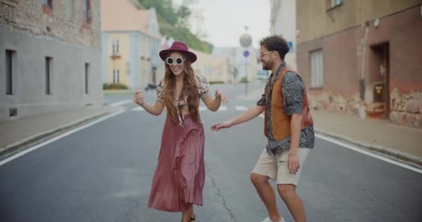 幸せなブロンドの女性は休日の間に街の道路でボーイフレンドと踊ることを楽しんでいます — ストック動画