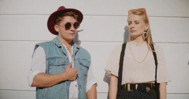 Güneşli bir günde erkek arkadaşının yanında duran, gözleri kapalı genç bir kadın.