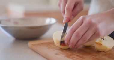 Mutfaktaki kadın elmalı pasta için elma soyuyor.