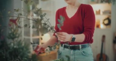Noel süslerini hazırlayan kadın manzarası. Noel tatili için çelenk hazırlayan kadın. Atölyede Noel Çelengi Yaratan Çiçekçi.