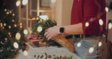 Noel süslerini hazırlayan kadın manzarası. Noel tatili için çelenk hazırlayan kadın. Atölyede Noel Çelengi Yaratan Çiçekçi.