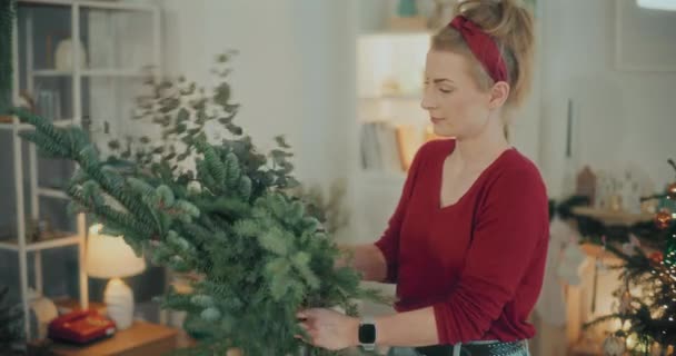 妇女准备圣诞装饰的观点 为圣诞节假期准备圣诞花环的女人 花匠在工作坊创造圣诞花环 — 图库视频影像