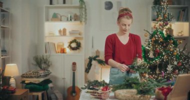 Noel tatili için çelenk hazırlayan bir kadın. Noel Dekorasyonu, Noel Çelengi Yapımı.