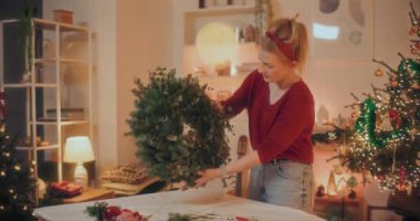 Noel tatili için çelenk hazırlayan bir kadın. Noel Dekorasyonu, Noel Çelengi Yapımı.