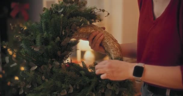 クリスマスの休日のためのクリスマスリースを作るためのファイアーブランチを切る女性 クリスマスの装飾 クリスマスの装飾 — ストック動画