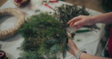 Noel tatili için çelenk hazırlayan bir kadın. Noel Dekorasyonu, Noel Çelengi Yapımı.