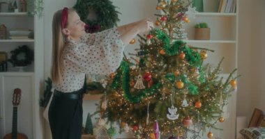 Noel ağacını süsleyen neşeli kadın manzarası Tatil için hazırlanıyor