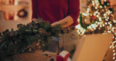 Noel tatili için çelenk hazırlayan bir kadın. Noel Dekorasyonu, Noel Çelengi Yapımı.