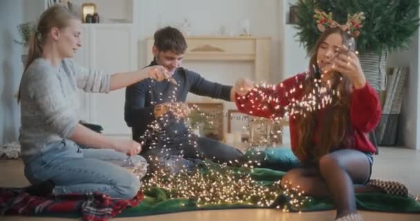 Giovani Uomini Donne Che Selezionano Luci Incandescenti Decorazione Natale Casa — Video Stock