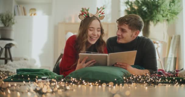 Gelukkig Vriendin Vriend Met Fotoalbum Liggend Thuis Tijdens Kerstvakantie — Stockvideo