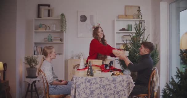 Jovem Mulher Dando Presentes Natal Para Amigos Masculinos Femininos Casa — Vídeo de Stock