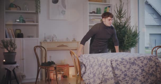 Mladý Muž Nastavení Ubrus Stůl Zatímco Stojí Obývacím Pokoji Doma — Stock video